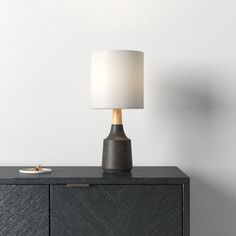 a table lamp sitting on top of a black cabinet