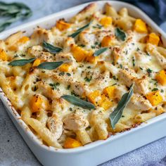 a casserole dish with chicken and butternuts in a white baking dish