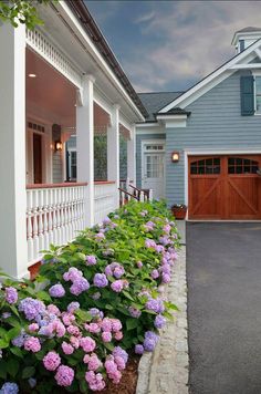 there is a driveway with flowers in the front and side of the house on the other side