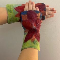 a woman's hand is covered with colorful felt