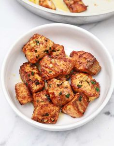 there are many pieces of tofu in the bowl on the marble counter top next to each other