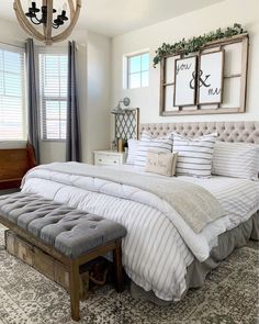 a large bed sitting in a bedroom next to a window with two framed pictures above it