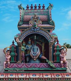 an elaborately decorated statue on the side of a building with blue skies in the background