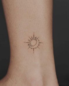 a small sun and moon tattoo on the side of a woman's foot,