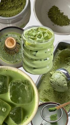 several bowls and spoons filled with different types of powdered green things in them