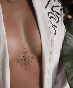 a woman's chest with a tattoo on her left side and an arrow in the middle