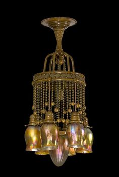 a chandelier with five lights hanging from it's sides and four bells on each side