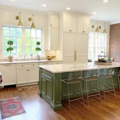 a kitchen with white cabinets and green island