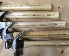 five hammers with names on them sitting next to each other and some woodworking tools