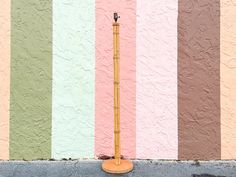 a tall wooden pole sitting in front of a colorful wall