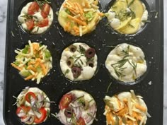 an assortment of appetizers in muffin tins on a marble countertop