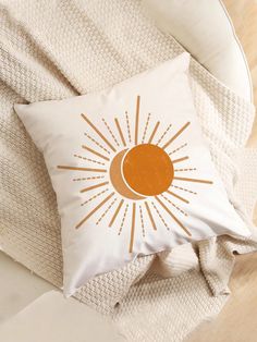 an orange and white pillow sitting on top of a bed