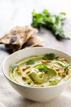 a white bowl filled with guacamole and nuts