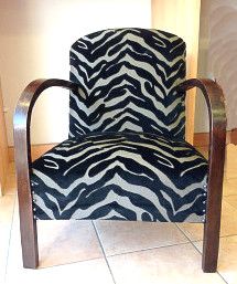 a zebra print chair sitting on top of a tile floor next to a wooden frame