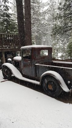 an old truck is parked in the snow