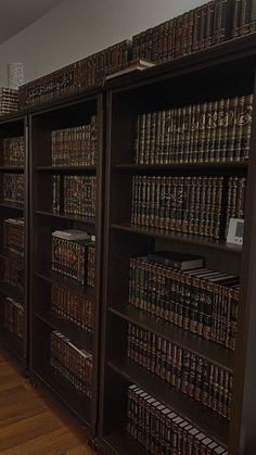 a long row of bookshelves filled with lots of books on top of hard wood floors