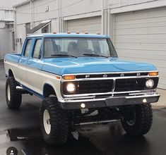 a blue pick up truck parked in front of a garage