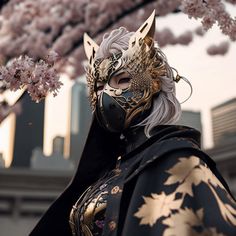 a woman wearing a black and gold mask under a cherry blossom tree with buildings in the background