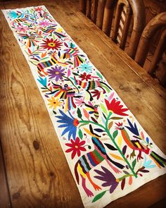 the table runner is decorated with colorful flowers