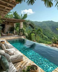 an outdoor swimming pool with chaise lounges and mountains in the backgroud