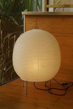 a white lamp sitting on top of a wooden floor