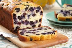 a loaf of blueberry bread sitting on top of a cutting board