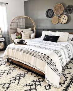 a bed sitting in a bedroom on top of a white and black rug next to a window