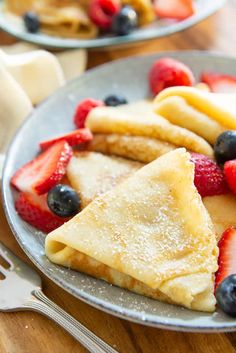 pancakes with berries and powdered sugar on a plate