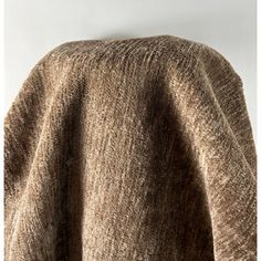 the back of a brown sweater hanging on a white wall