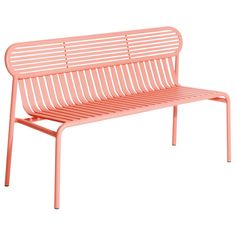 a pink metal bench sitting on top of a white floor