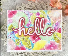 a card with the word hello on it next to flowers and crochet doily