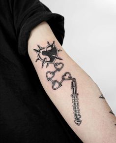 a man with a tattoo on his arm holding a wrench and heart shaped key