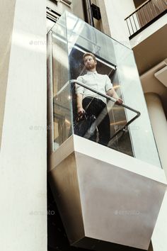 a man standing on an escalator with his luggage in the air - stock photo - images