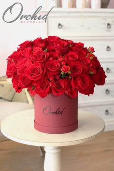 red roses in a pink box on a white table