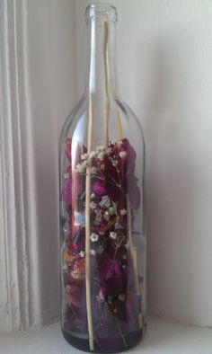 flowers in a glass bottle with sticks sticking out of it