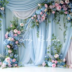 the backdrop is decorated with blue and pink flowers