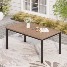 a table sitting on top of a rug in front of a house