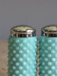 two blue salt and pepper shakers sitting on top of a table