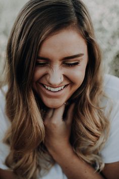 a woman smiling with her hands on her chest