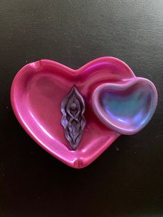 a pink heart shaped dish with a skull on it