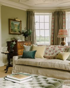 a living room filled with lots of furniture and pillows on top of a couch next to a window