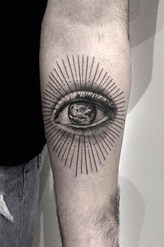 a man's arm with an eye tattoo on it