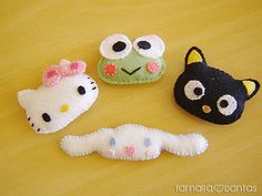 three different types of stuffed animals sitting on a wooden table with one black cat, the other white