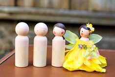 a group of wooden dolls sitting next to each other on top of a brown table