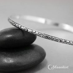 This Floral Sterling Silver Bangle Bracelet measures 3 mm wide (about .11") and features a lovely stylized tendril and vine motif. The inside is gently curved for comfortable wear, and has been antiqued and then repolished to show the delicate details of the patterning. I also offer a brightly polished finish, if you prefer. This bracelet can be made in any size you need and makes lovely wedding jewelry, commitment jewelry, or promise jewelry.Bangle Sizes:●Extra Small - 2 1/4" diameter, approx. Adjustable Bracelets With Intricate Design, Etched Sterling Silver Bracelet As Gift, Etched Sterling Silver Bracelet Gift, Elegant Adjustable Engraved Bangle, Elegant Engraved Adjustable Bangle, Elegant Etched Bangle Bracelet, Adjustable Round Bangle With Intricate Design, Etched Round Bracelet As Gift, Adjustable Round Etched Bracelets