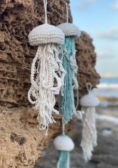 some white and blue decorations hanging from the side of a rock