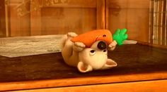 a stuffed animal with a carrot on top of it's head sitting on a table