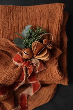 an orange blanket with some green leaves on it and a stuffed animal in the middle