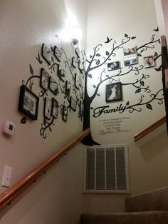 a family tree on the wall next to stairs with pictures hanging from it's sides