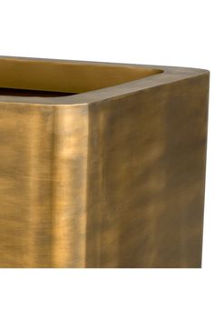 a gold square vase sitting on top of a table